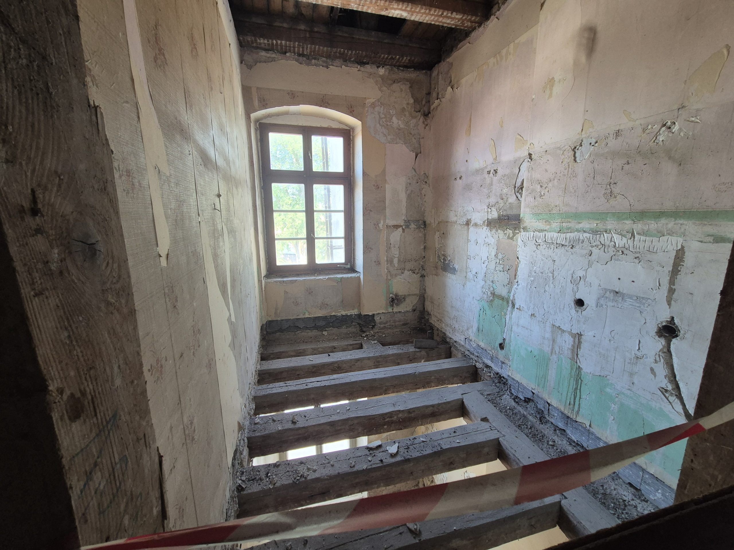 Solives d'un plancher ancien mises à nu, encastrées dans la maçonnerie